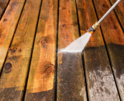 Wood deck in the process of having dirt and grime cleaned by a residential pressure washing service